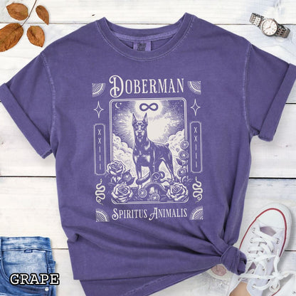 Purple Comfort Colors t-shirt featuring a Doberman Pinscher tarot card design with Gothic roses and mystical symbols, perfect for Goth dog lovers and dark aesthetic Doberman fans.