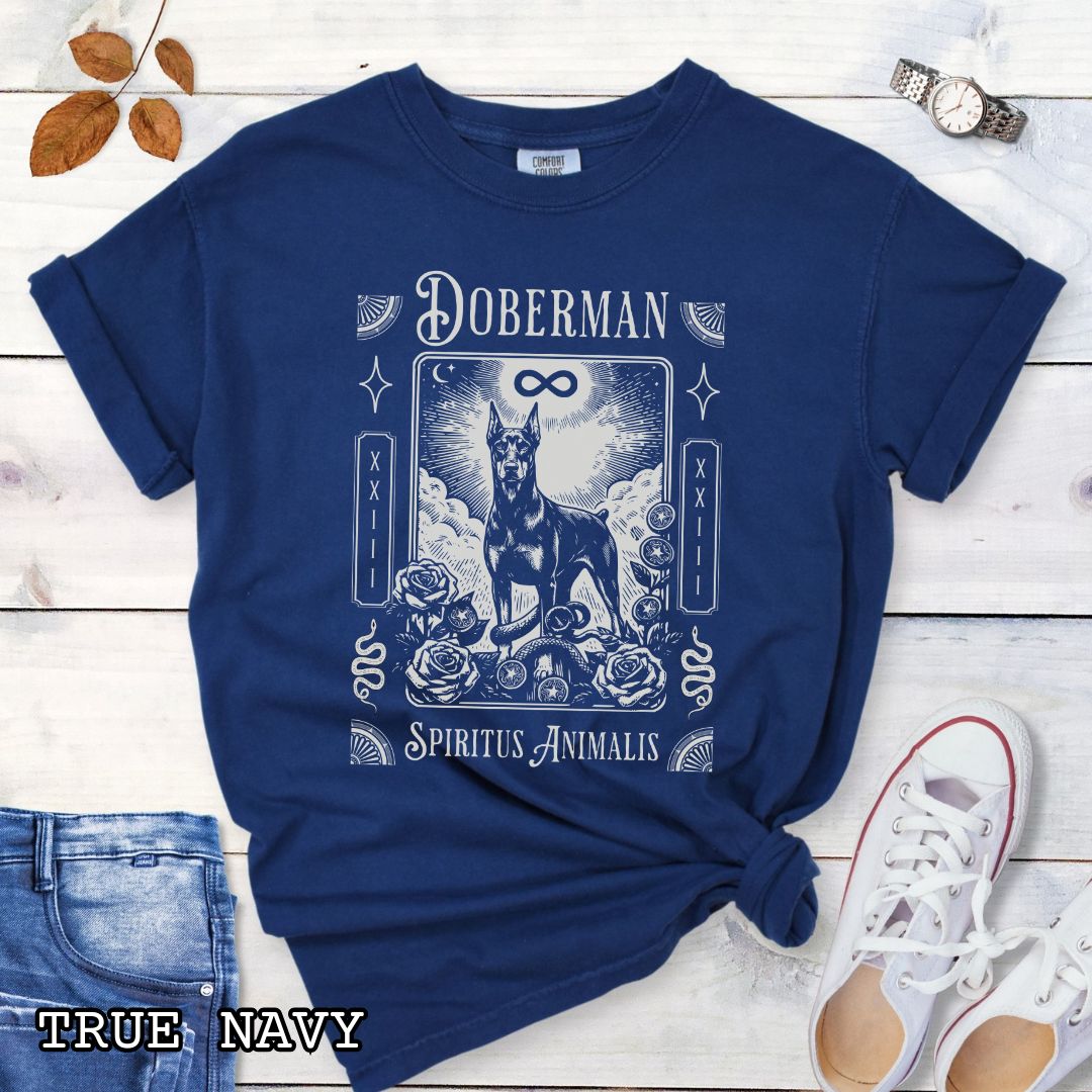 Navy blue Comfort Colors t-shirt featuring a Doberman Pinscher tarot card design with Gothic roses and mystical symbols, perfect for Goth dog lovers and dark aesthetic Doberman fans.