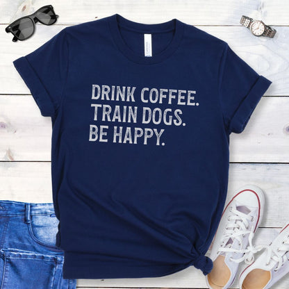 Navy blue dog trainer t-shirt with the humorous text 'DRINK COFFEE. TRAIN DOGS. BE HAPPY.' in grunge retro lettering. 