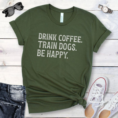 Black dog training t-shirt with the humorous text 'DRINK COFFEE. TRAIN DOGS. BE HAPPY.' in grunge retro lettering. 