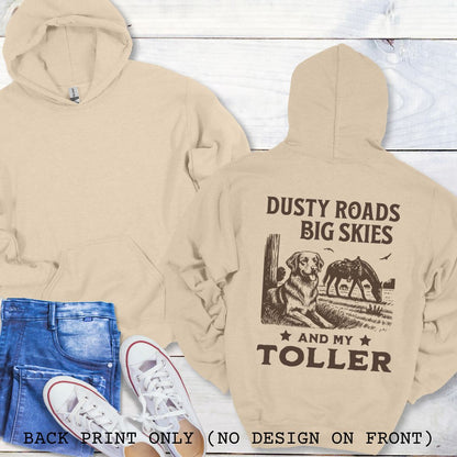 Beige hoodie with 'Dusty Roads Big Skies And My Toller' text and graphic on the back, paired with jeans and sneakers on a light wooden surface.