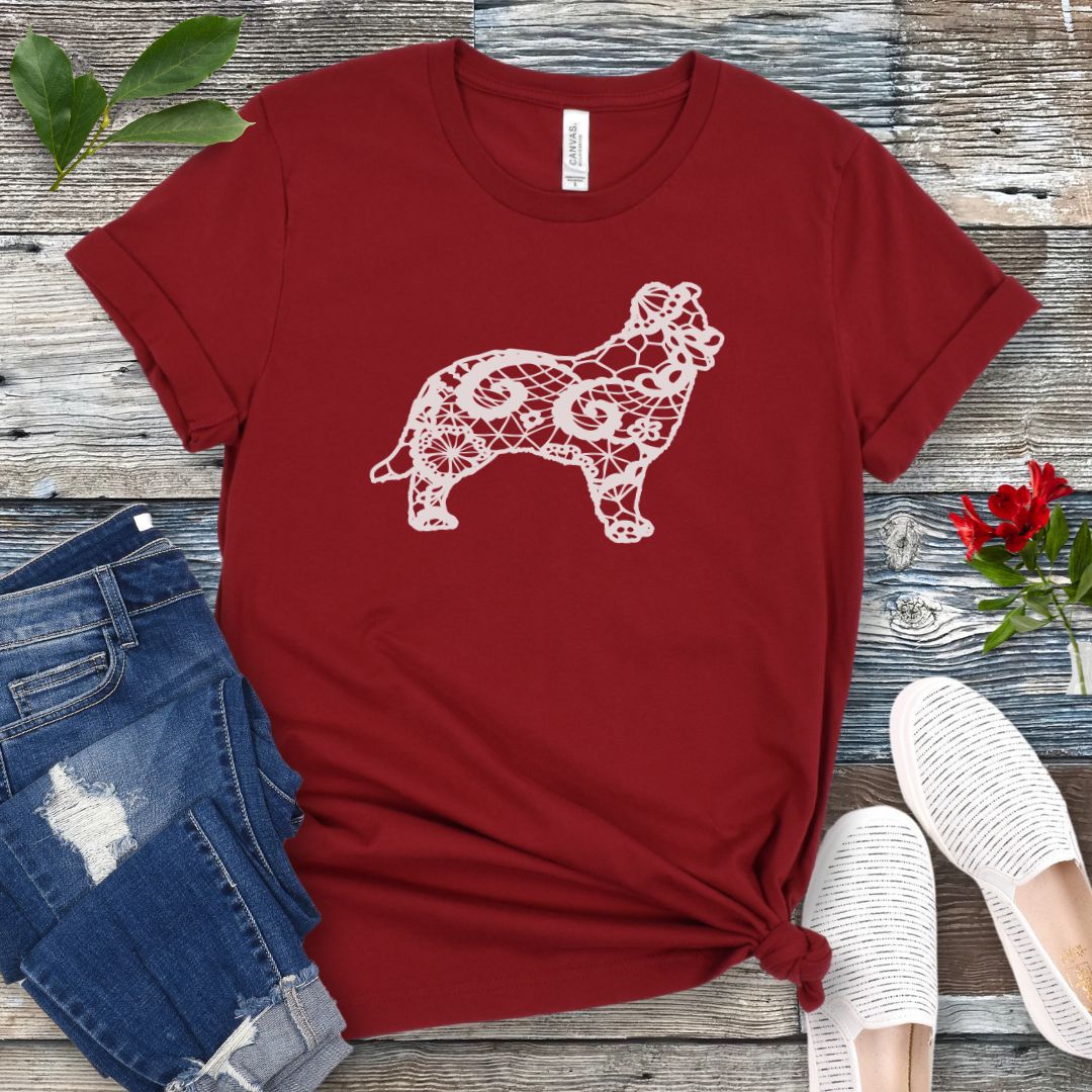 Dark red t-shirt for Border Collie moms with lace-pattern filled Border Collie silhouette, shown on a wooden surface with accessories.
