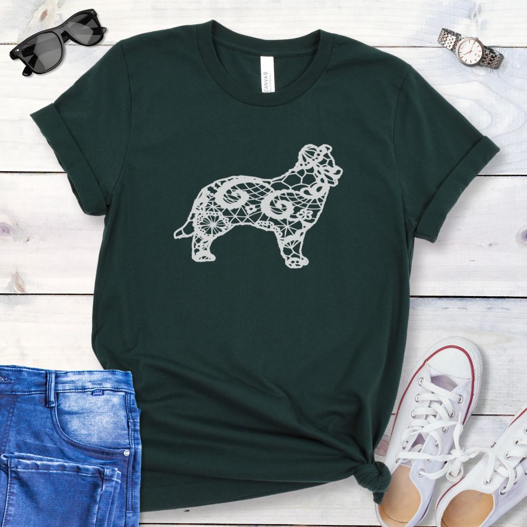 Dark green t-shirt for Border Collie moms with lace-pattern filled Border Collie silhouette, shown on a wooden surface with accessories.