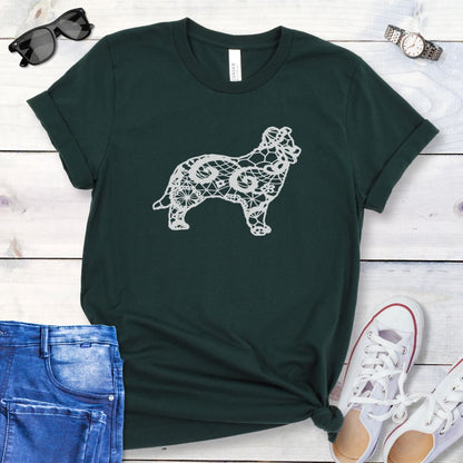 Dark green t-shirt for Border Collie moms with lace-pattern filled Border Collie silhouette, shown on a wooden surface with accessories.
