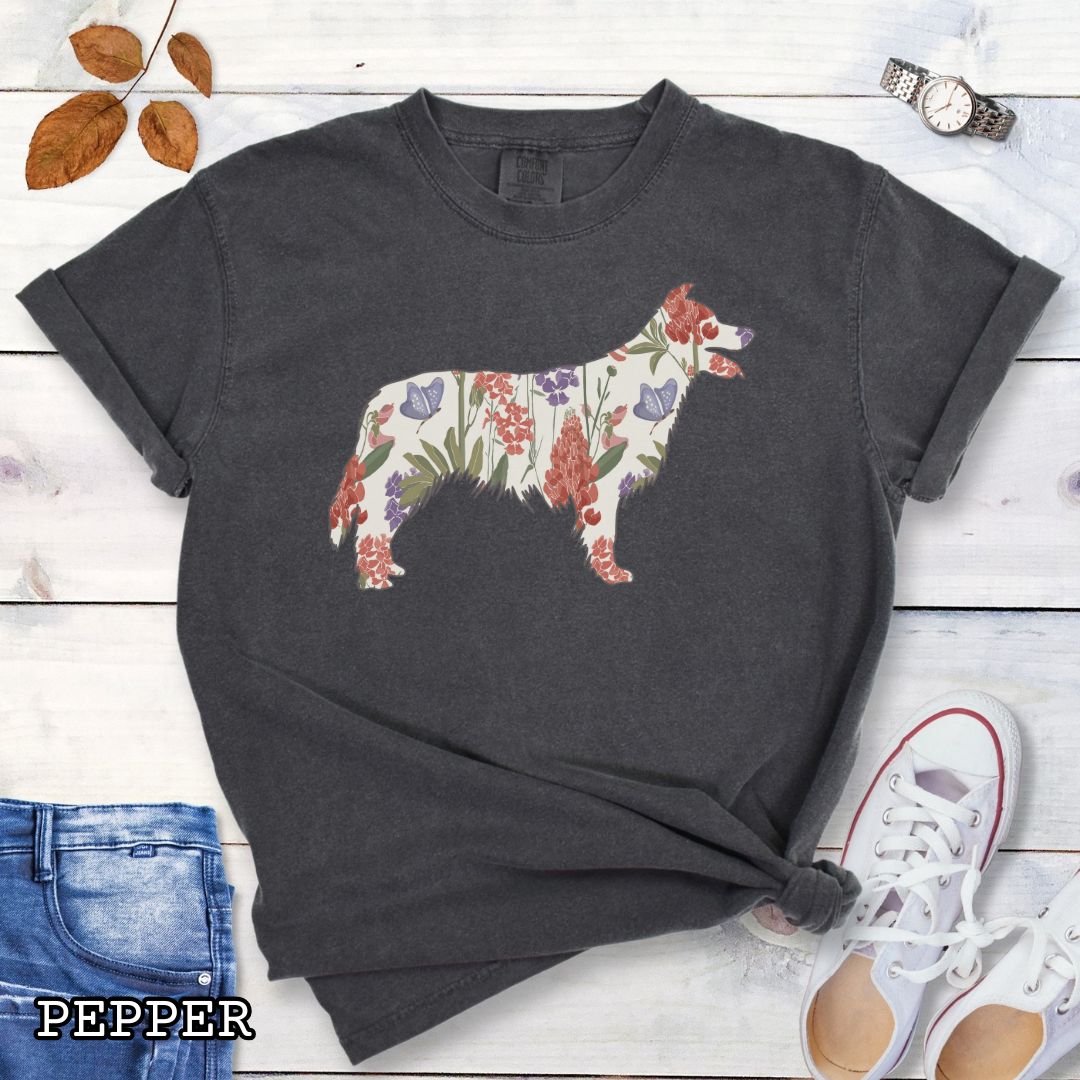 Dark Grey Comfort Colors t-shirt with floral Border Collie dog design on a wooden surface with jeans and shoes.