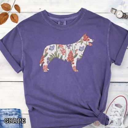 Purple Comfort Colors t-shirt with floral Border Collie dog design on a wooden surface with jeans and shoes.