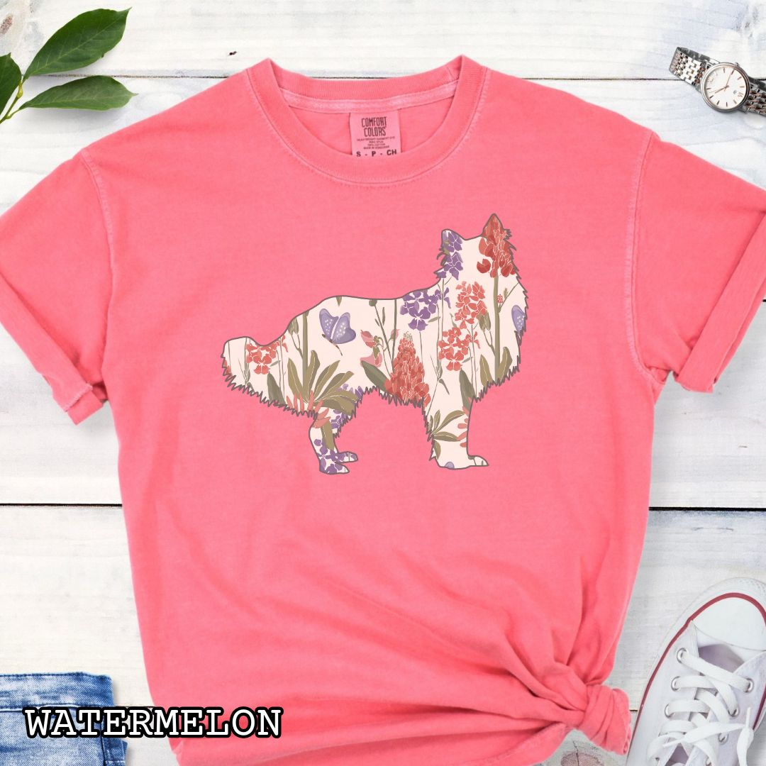 Watermelon-colored Comfort Colors t-shirt with Rough Collie silhouette filled with floral pattern, presented on a wooden surface with jeans and shoes.
