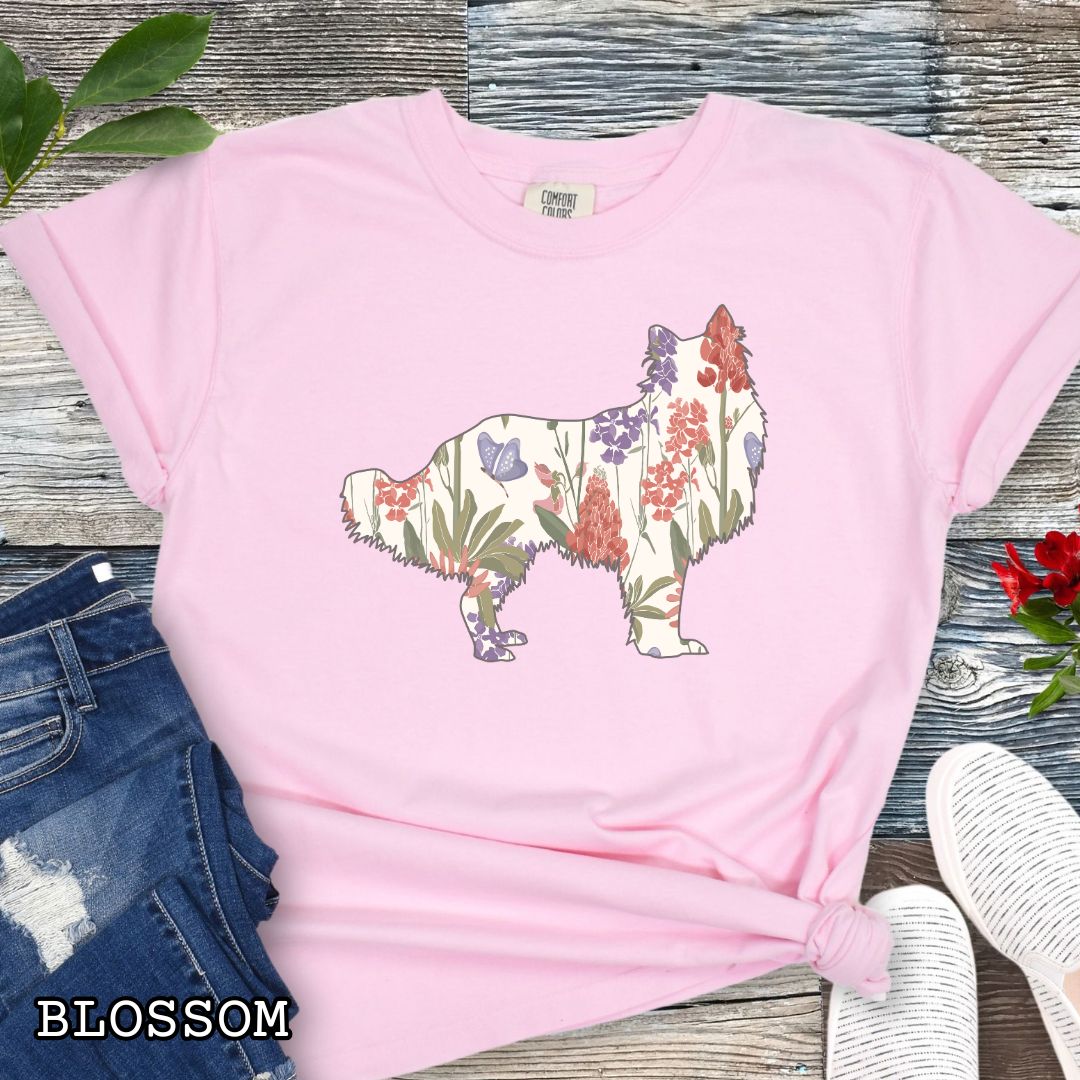 Pink Comfort Colors t-shirt with Rough Collie silhouette filled with floral pattern, presented on a wooden surface with jeans and shoes.