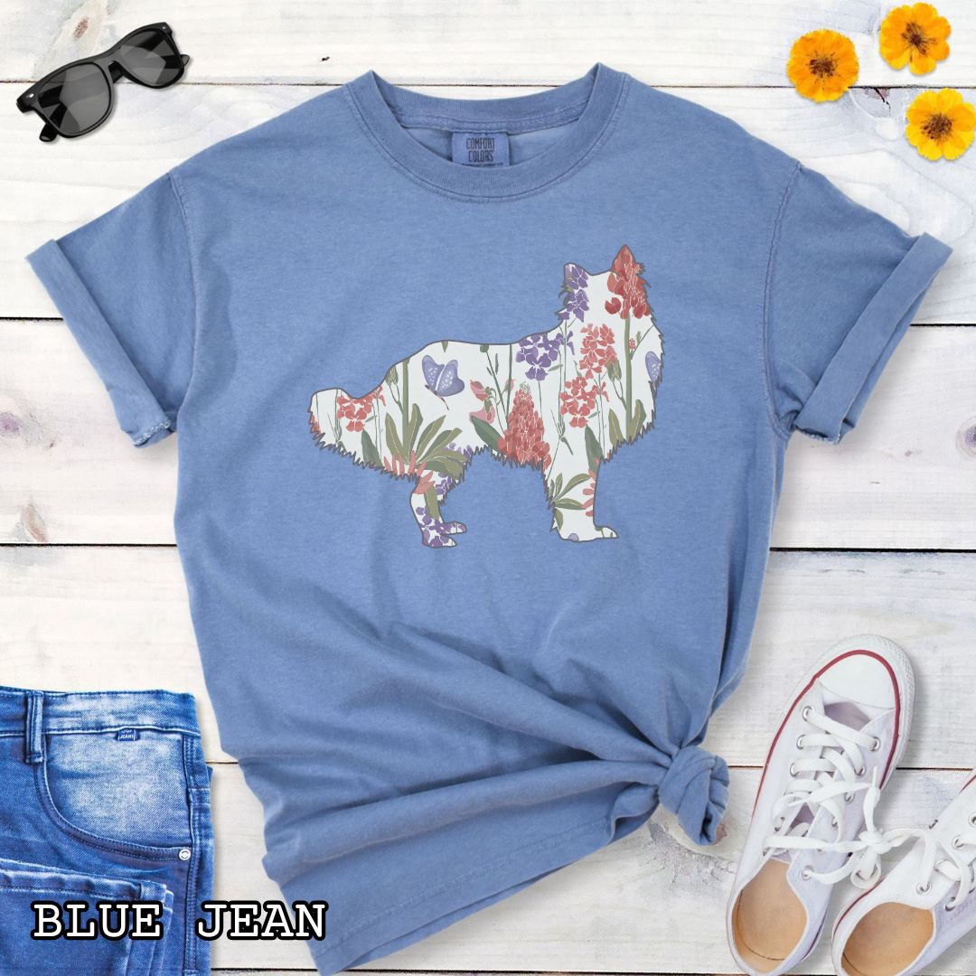 Blue Comfort Colors t-shirt with Rough Collie silhouette filled with floral pattern, presented on a wooden surface with jeans and shoes.