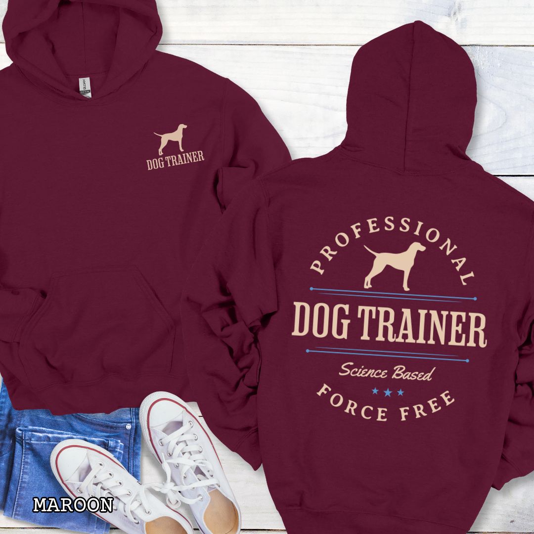 Front and back view of a maroon dog training hoodie with the text 'PROFESSIONAL DOG TRAINER, Science Based, Force Free"' and custom dog breed silhouette in a vintage, badge style design. The shirt is displayed flat with a pair of blue jeans and white shoes.