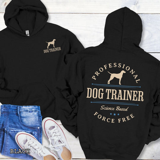 Front and back view of a black dog training hoodie with the text 'PROFESSIONAL DOG TRAINER, Science Based, Force Free"' and custom dog breed silhouette in a vintage, badge style design. The shirt is displayed flat with a pair of blue jeans and white shoes.