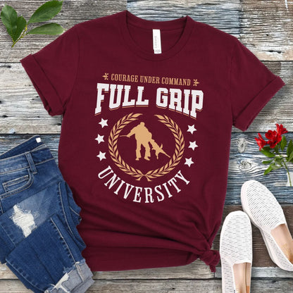 Maroon Schutzhund/IGP t-shirt with 'Full Grip University' text , laurels, stars and bite work graphic, presented on a wooden surface with jeans and shoes.