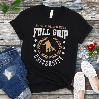 Black Schutzhund/IGP t-shirt with 'Full Grip University' text , laurels, stars and bite work graphic, presented on a wooden surface with jeans and shoes.