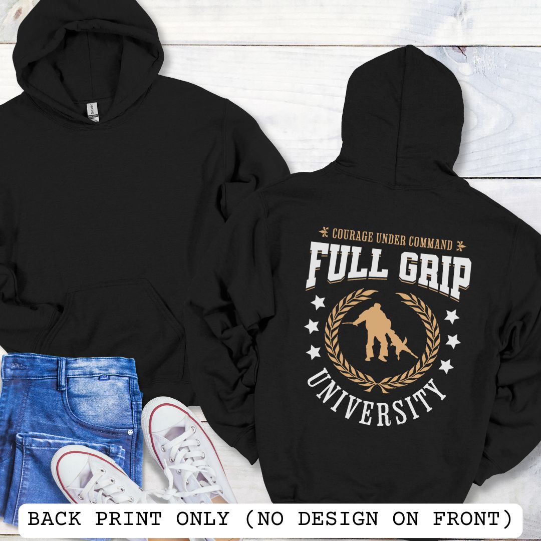 Back view of a black Schutzhund/IGP hoodie with 'Full Grip University' text , laurels, stars and bite work graphic, presented on a wooden surface with jeans and shoes.