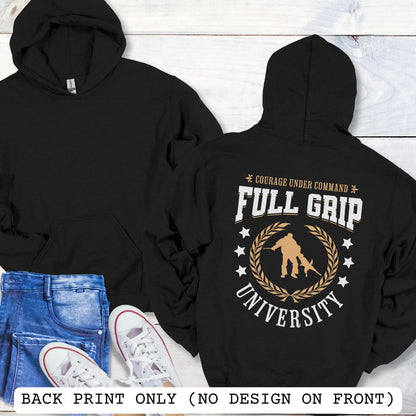 Back view of a black Schutzhund/IGP hoodie with 'Full Grip University' text , laurels, stars and bite work graphic, presented on a wooden surface with jeans and shoes.