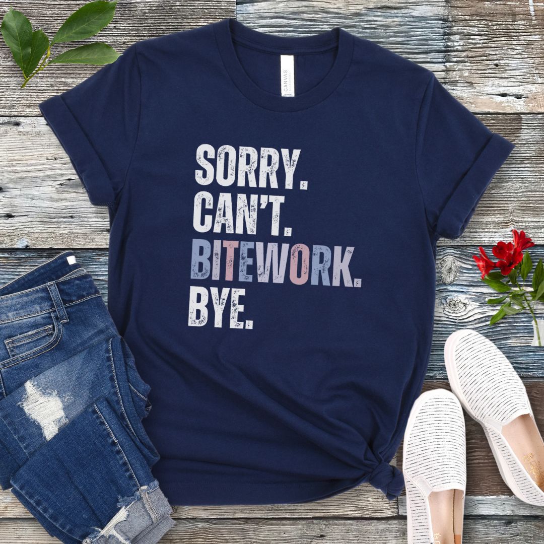 Navy blue protection dog sport t-shirt with colorful, distressed text 'SORRY. CAN'T. BITEWORK. BYE.', presented on a wooden surface with jeans and shoes.