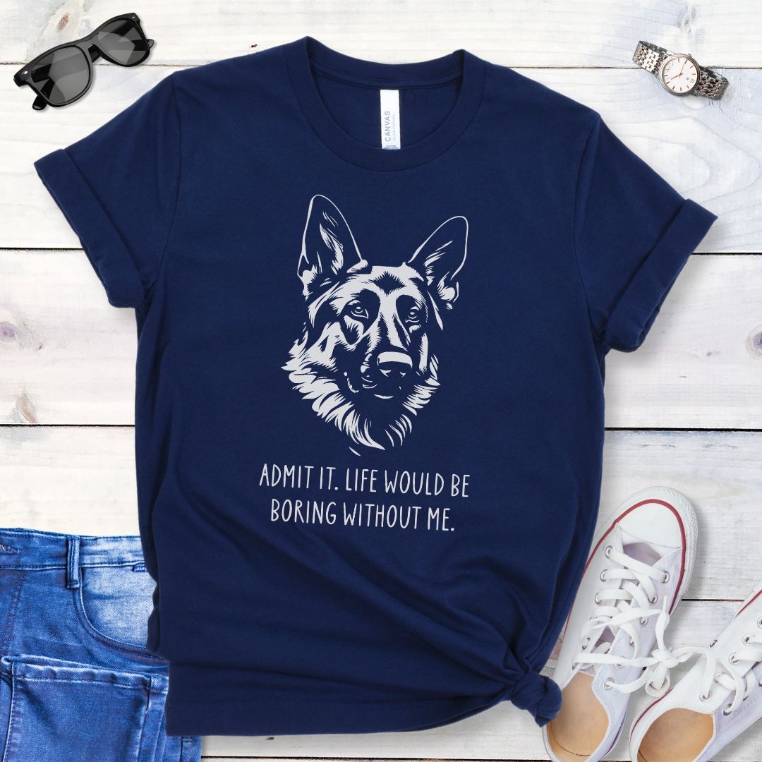 Navy blue t-shirt for German Shepherd lovers with with Shepherd dog face graphic and humorous text 'Admit it. Life would be boring without me'. Shown on a wooden surface with accessories.