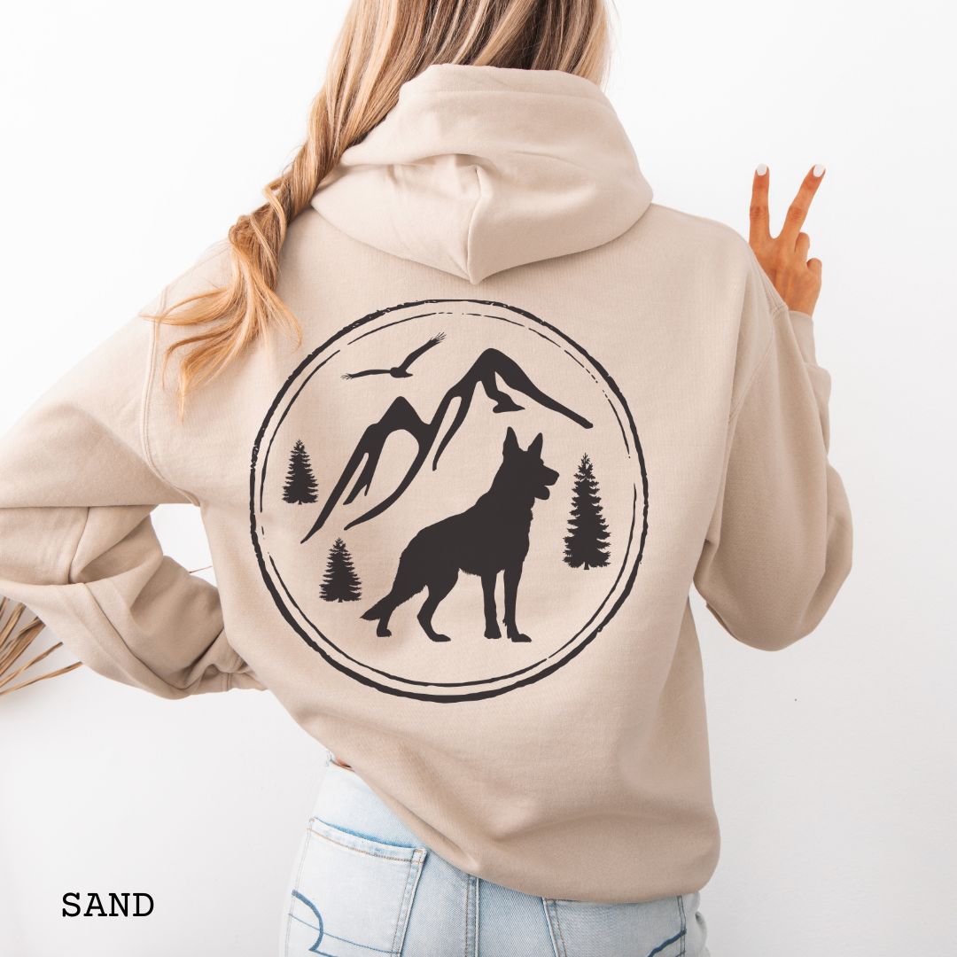 Sand Gildan 18500 German Shepherd Mountain Adventure hoodie featuring a large vintage-style back print with GSD silhouette, mountains, pine trees, and birds for hiking and outdoor dog lovers.