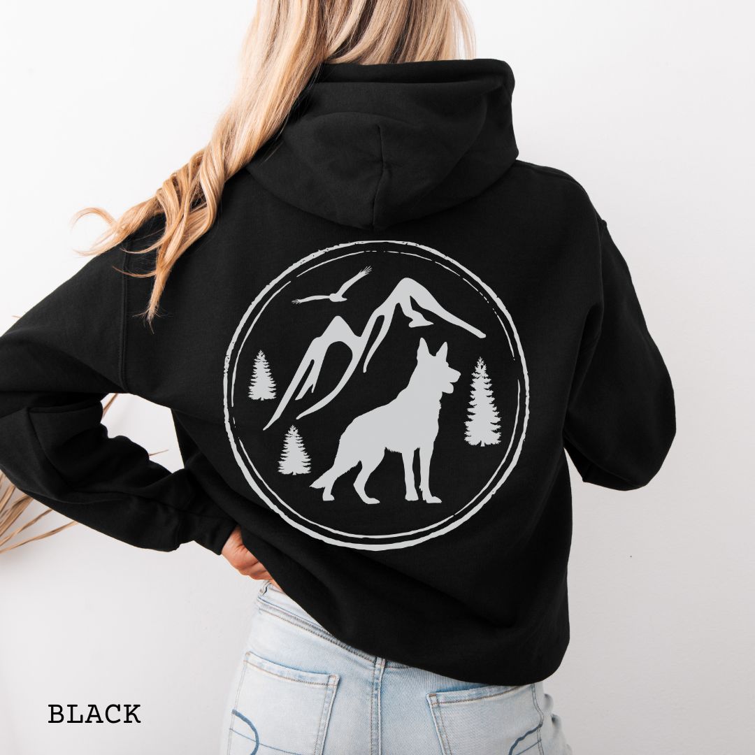 Black Gildan 18500 German Shepherd Mountain Adventure hoodie featuring a large vintage-style back print with GSD silhouette, mountains, pine trees, and birds for hiking and outdoor dog lovers.