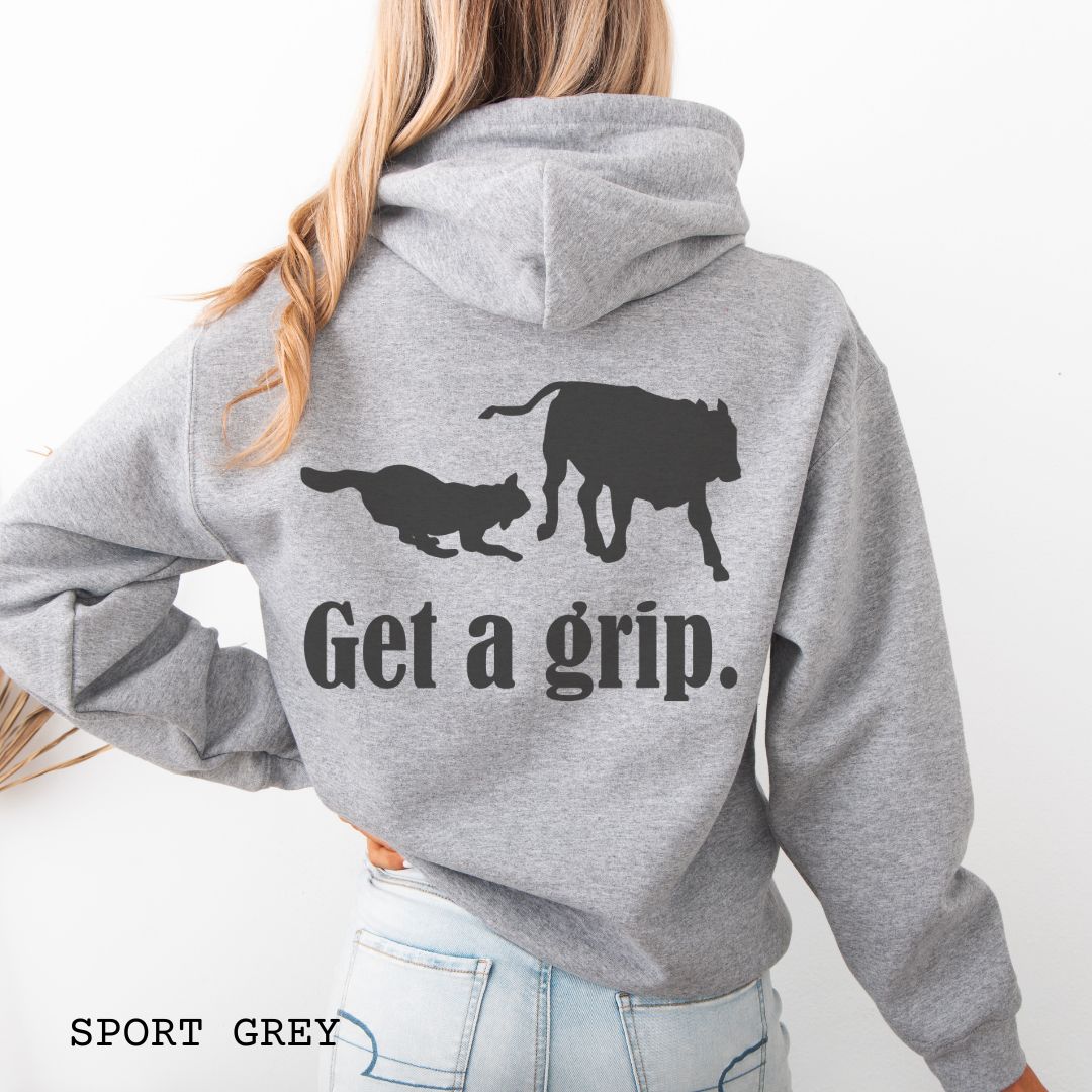 Grey back print hoodie with a graphic of a Heeler dog herding a cow and the text 'Get a grip.' Worn by a person.