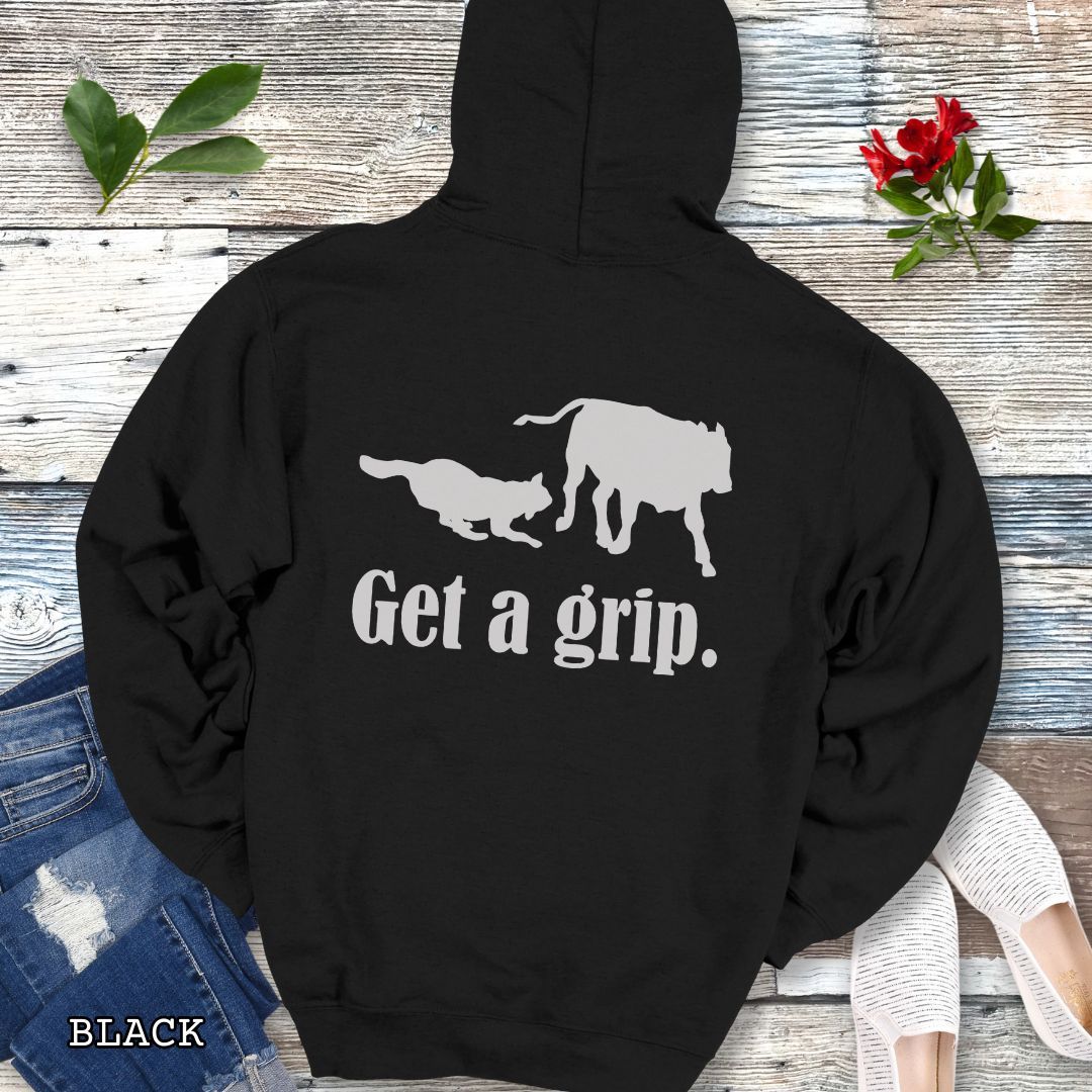 Black back print hoodie with a graphic of a Heeler dog herding a cow and the text 'Get a grip.' Worn by a person.