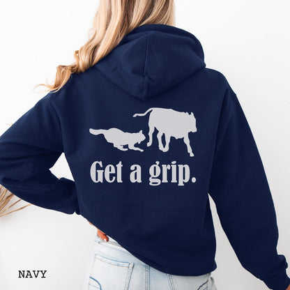 Navy blue back print hoodie with a graphic of a Heeler dog herding a cow and the text 'Get a grip.' Worn by a person.