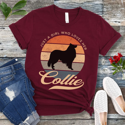 Maroon Collie mom t-shirt with a vintage sunset design with Rough Collie and the text 'Just a Girl Who Loves Her Collie', shown on a wooden surface with jeans and shoes.