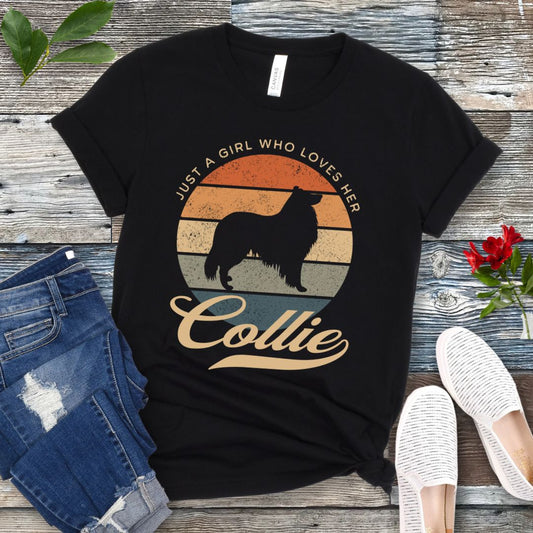 Black Collie mom t-shirt with a vintage sunset design with Rough Collie and the text 'Just a Girl Who Loves Her Collie', shown on a wooden surface with jeans and shoes.