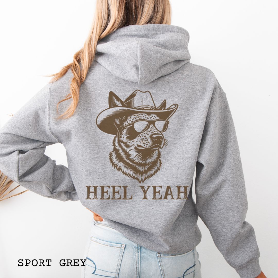 Grey Australian Cattle Dog hoodie with a graphic of a Heeler dog in cowboy hat and sunglasses,  and 'HEEL YEAH' text on the back, worn by a person.