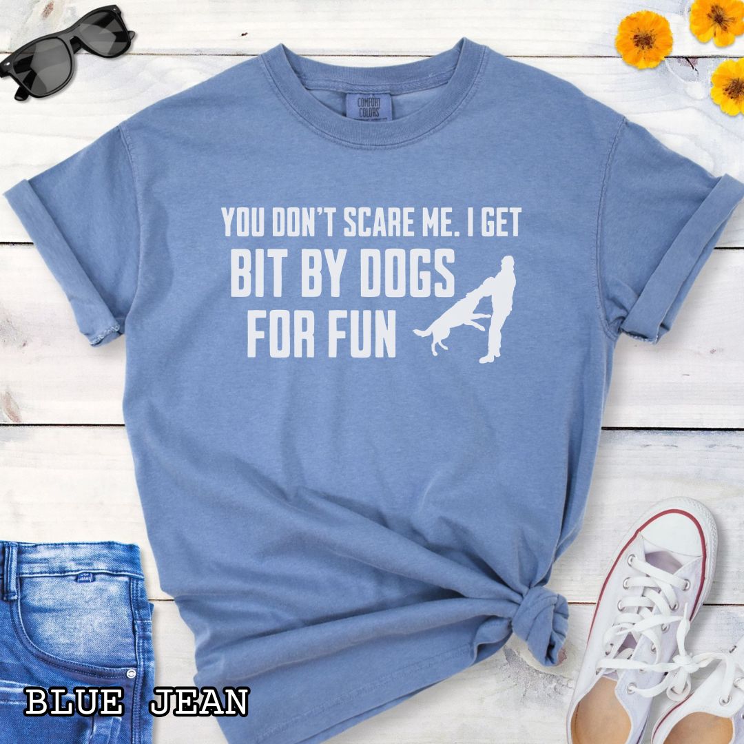 Blue Comfort Colors t-shirt featuring the phrase You Don't Scare Me. I Get Bit by Dogs for Fun with K9 bite work silhouette, funny Schutzhund shirt for IGP decoys, Schutzhund helpers, working dog handlers, protection sports enthusiasts, and IPO competitors.