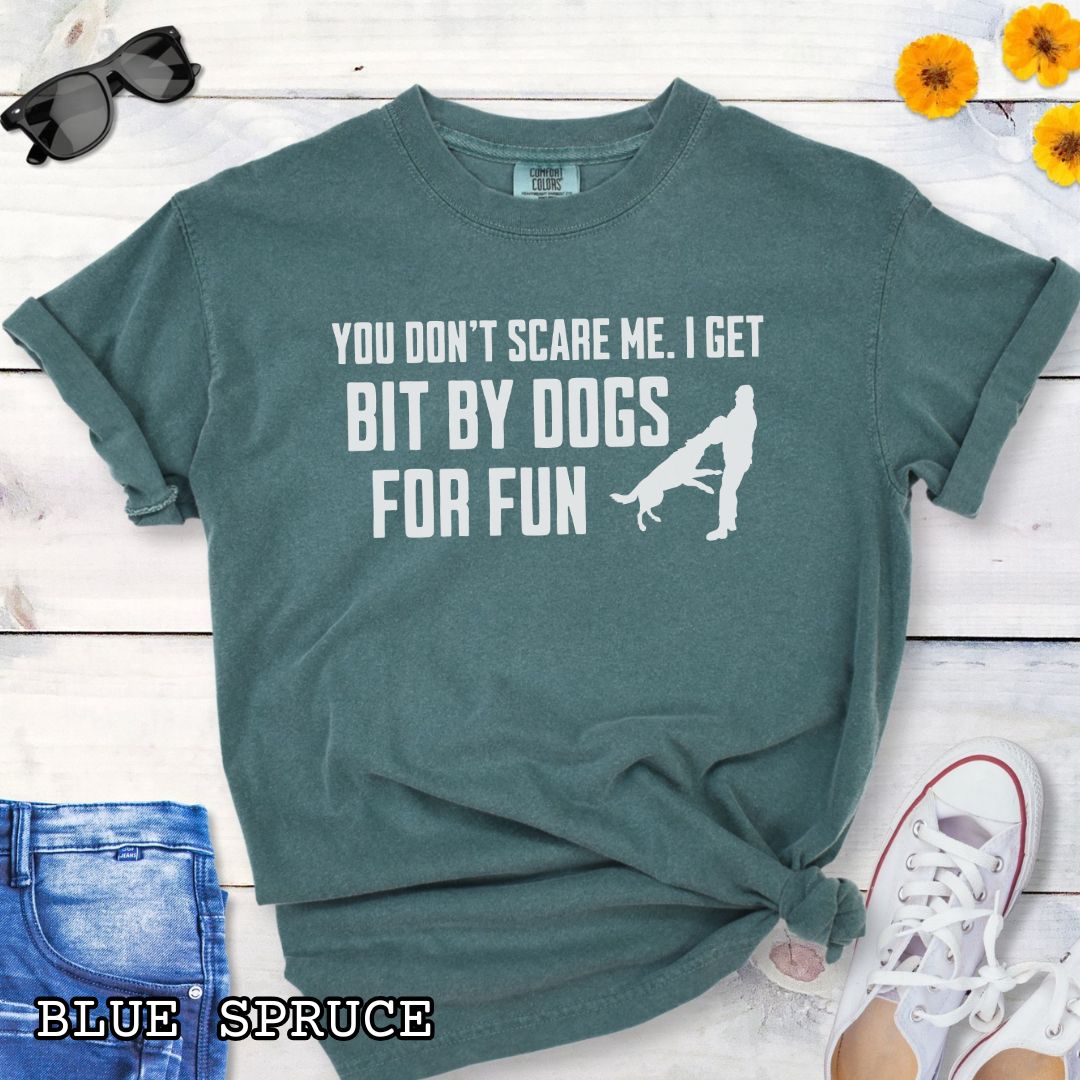 Green Comfort Colors t-shirt featuring the phrase You Don't Scare Me. I Get Bit by Dogs for Fun with K9 bite work silhouette, funny Schutzhund shirt for IGP decoys, Schutzhund helpers, working dog handlers, protection sports enthusiasts, and IPO competitors.