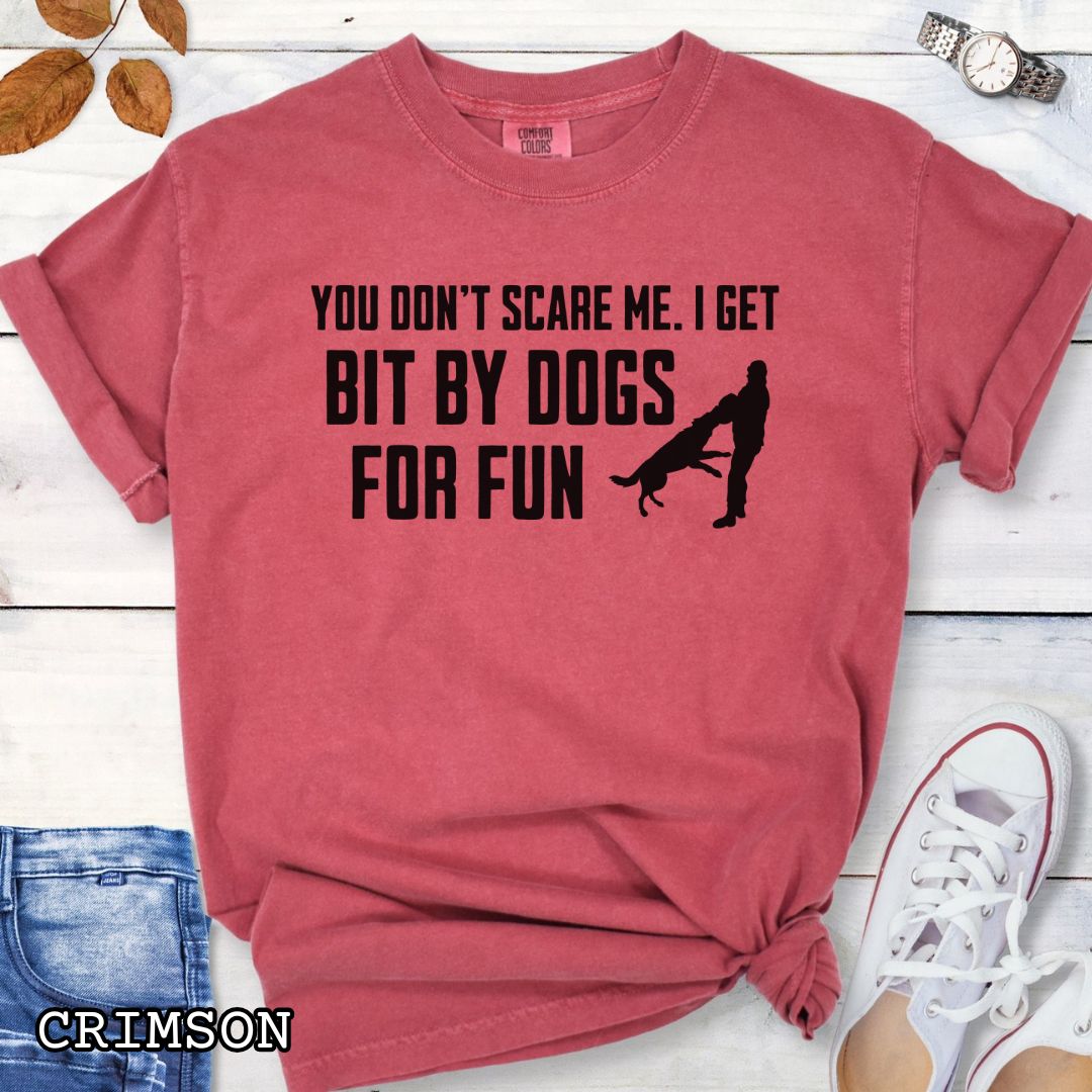 Red Comfort Colors t-shirt featuring the phrase You Don't Scare Me. I Get Bit by Dogs for Fun with K9 bite work silhouette, funny Schutzhund shirt for IGP decoys, Schutzhund helpers, working dog handlers, protection sports enthusiasts, and IPO competitors.
