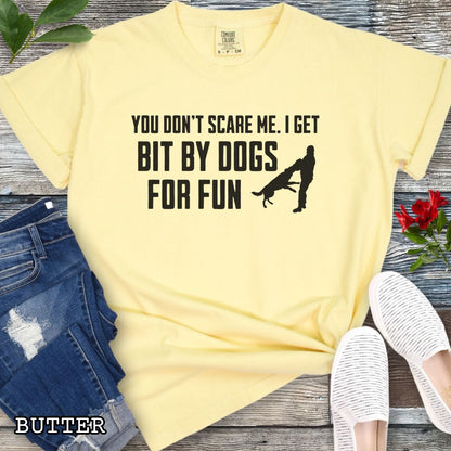 Yellow Comfort Colors t-shirt featuring the phrase You Don't Scare Me. I Get Bit by Dogs for Fun with K9 bite work silhouette, funny Schutzhund shirt for IGP decoys, Schutzhund helpers, working dog handlers, protection sports enthusiasts, and IPO competitors.