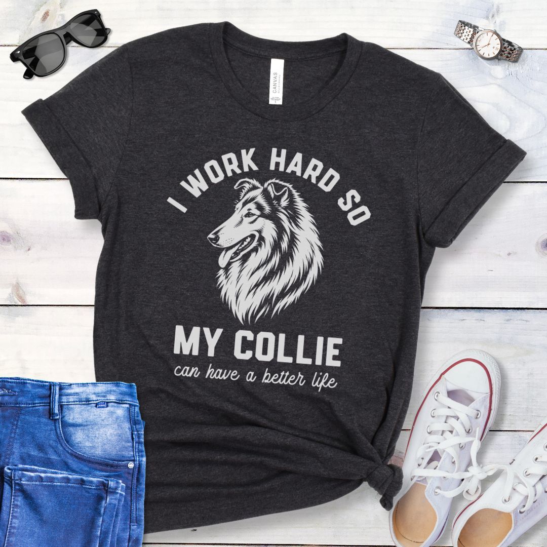 Dark grey unisex t-shirt for Rough Collie lovers with linocut-style breed head study graphic and humorous text 'I work hard so my Collie can have a better life', shown on a wooden surface with jeans and shoes. 