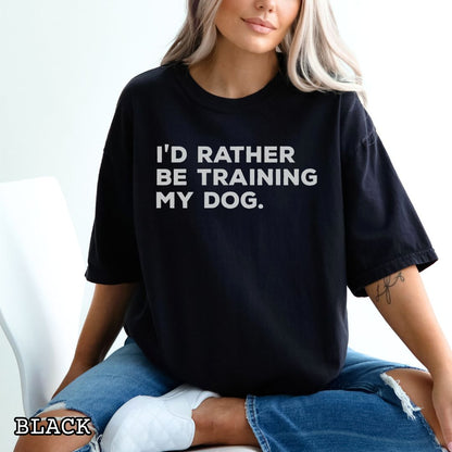 Person wearing a black t-shirt with 'I'd rather be training my dog' text.