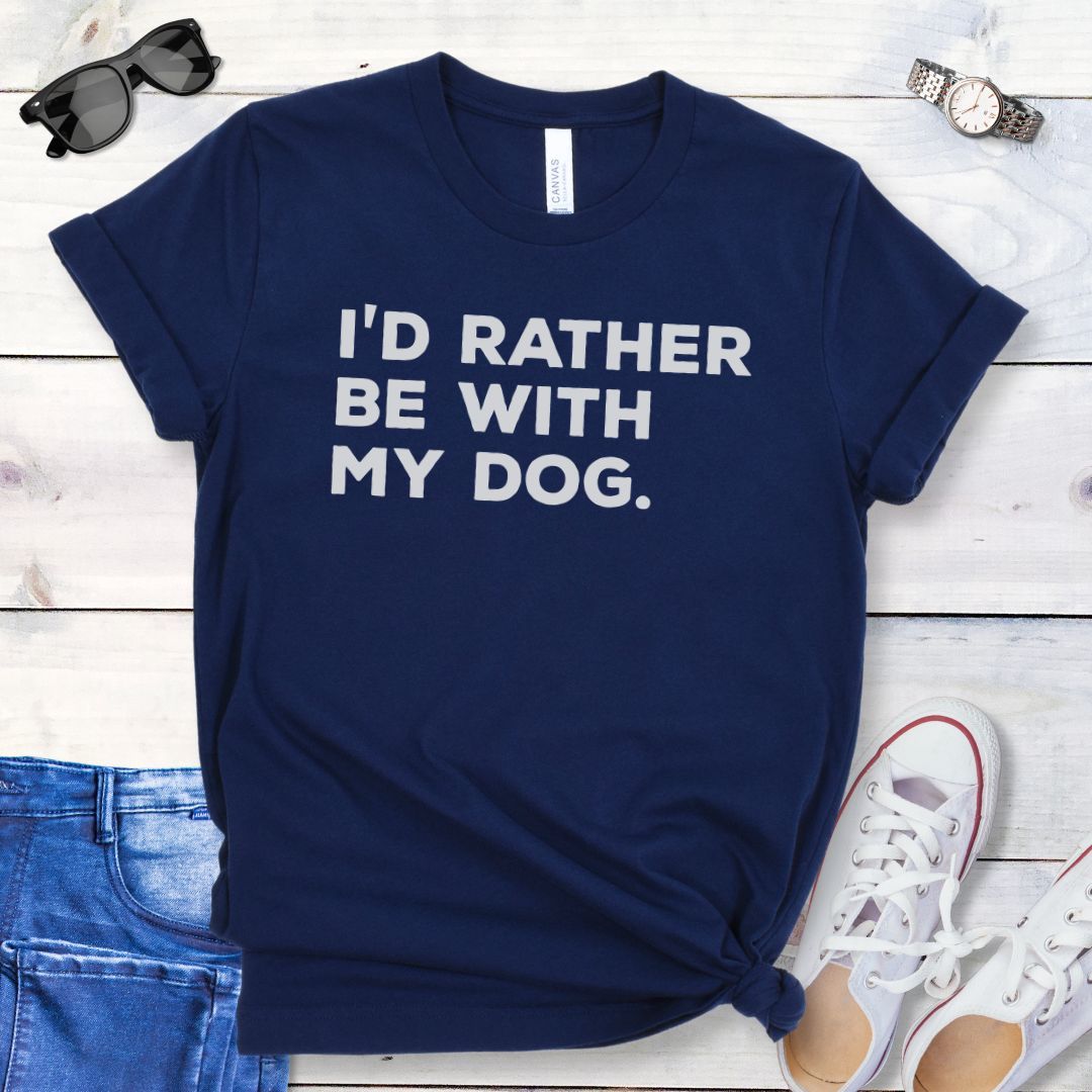Navy t-shirt for dog people with 'I'd Rather Be With My Dog' text in bold lettering, shown on a wooden surface with jeans and shoes.