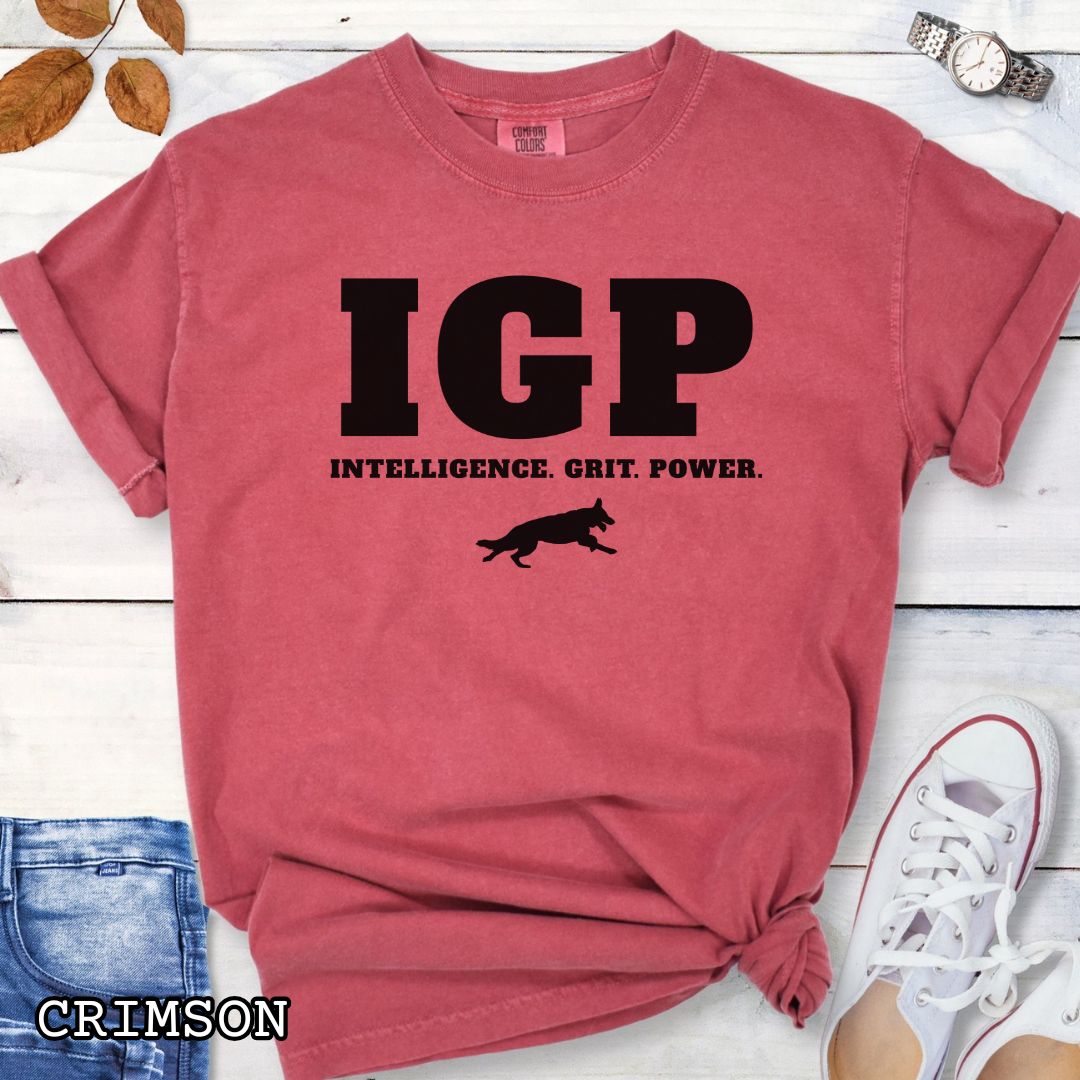 Red Comfort Colors t-shirt featuring the IGP Intelligence. Grit. Power. design with working dog silhouette, Schutzhund shirt for IGP competitors, IPO handlers, protection sports enthusiasts, and working dog trainers.