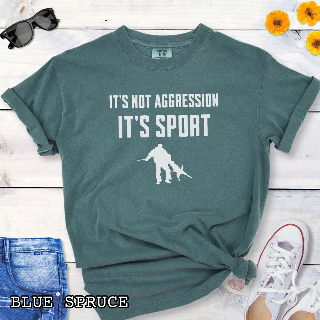 Green Comfort Colors t-shirt for Schutzhund/IGP bitework dog trainers with 'It's not aggression, it's sport' text and graphic on a wooden surface.