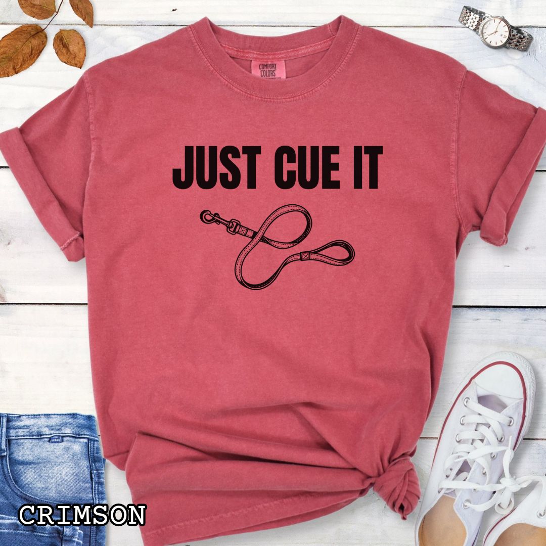 Red Comfort Colors t-shirt featuring a Just Cue It text with leash graphic, a positive reinforcement dog training shirt for dog trainers and reward-based training enthusiasts.