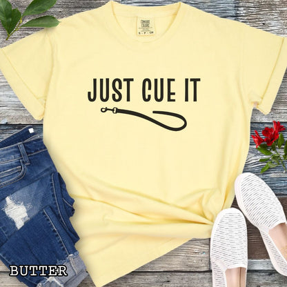 Yellow Comfort Colors t-shirt featuring a Just Cue It text with leash graphic, a positive reinforcement dog training shirt for dog trainers and reward-based training enthusiasts.