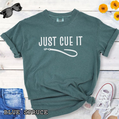 Green Comfort Colors t-shirt featuring a Just Cue It text with leash graphic, a positive reinforcement dog training shirt for dog trainers and reward-based training enthusiasts.