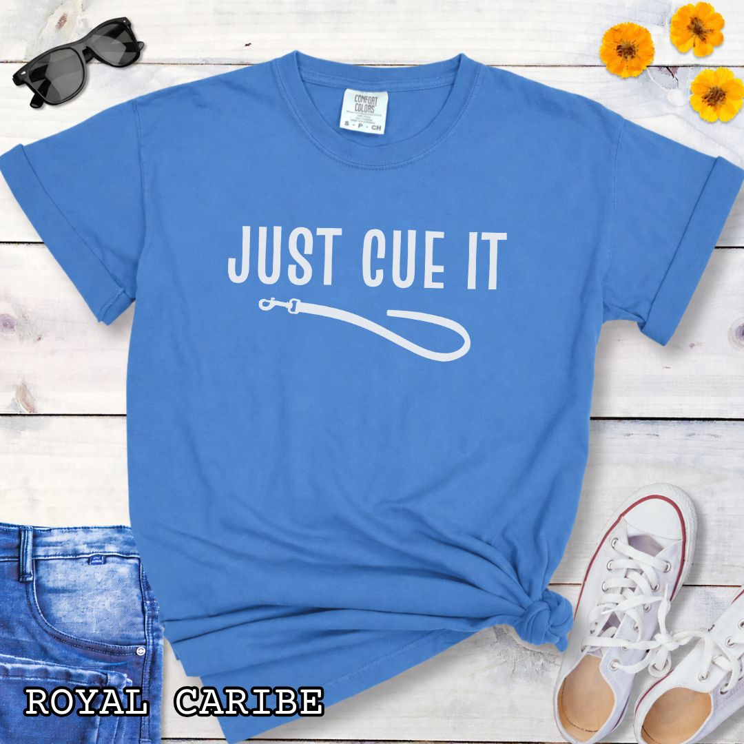 Royal blue Comfort Colors t-shirt featuring a Just Cue It text with leash graphic, a positive reinforcement dog training shirt for dog trainers and reward-based training enthusiasts.