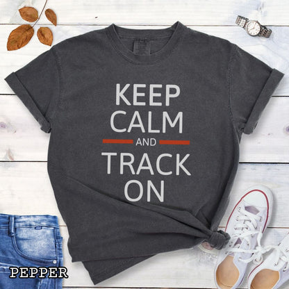 Dark grey dog tracking training t-shirt with 'Keep Calm and Track On' in bold text on a wooden surface with jeans and sneakers.