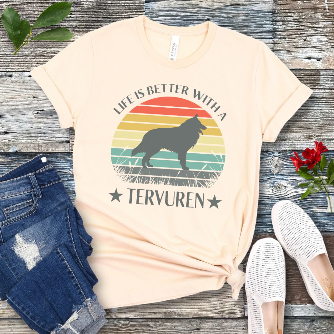 Beige t-shirt for Belgian Tervuren lovers with a retro sunset graphic design featuring a Tervuren dog silhouette and text 'Life is better with a Tervuren', shown on a wooden surface.