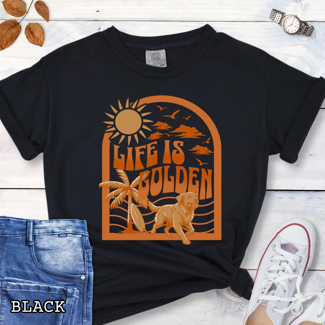 Black Comfort Colors Golden Retriever t-shirt featuring retro tropical sunset design with palm trees, surfboard, and Life Is Golden slogan, perfect for Golden Retriever lovers, beach dog moms, and summer dog lover gifts.