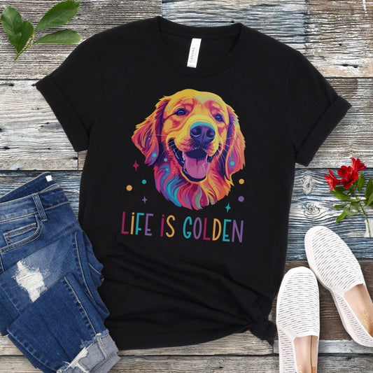 Black t-shirt with colorful Golden Retriever dog graphic and 'Life is Golden' text on a wooden surface with jeans and shoes.