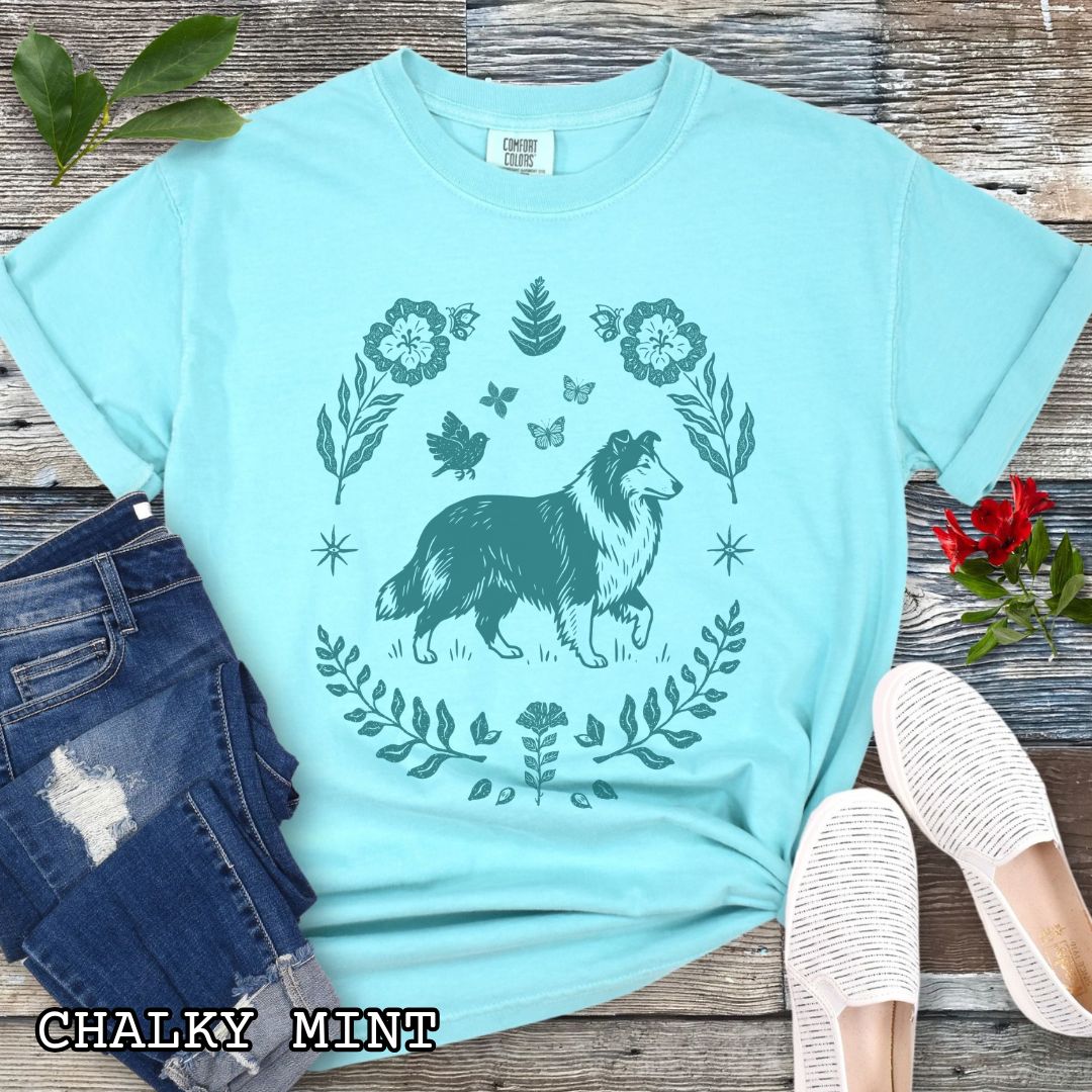 Bright teal Comfort Colors t-shirt with folk art style Rough Collie t-shirt featuring a linocut-inspired collie surrounded by floral and botanical elements in a boho cottagecore design. Perfect dog lover gift for Collie owners.
