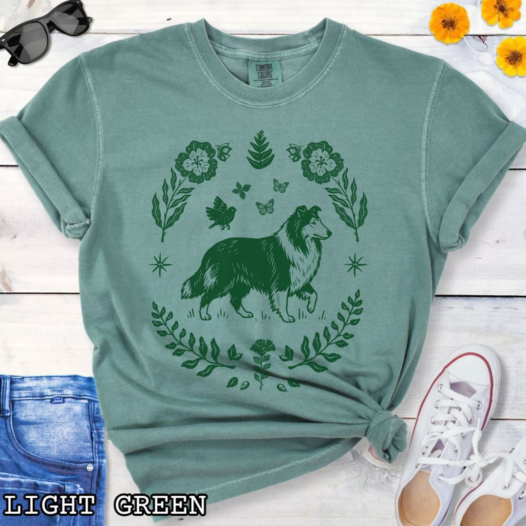 Green Comfort Colors t-shirt with folk art style Rough Collie t-shirt featuring a linocut-inspired collie surrounded by floral and botanical elements in a boho cottagecore design. Perfect dog lover gift for Collie owners.