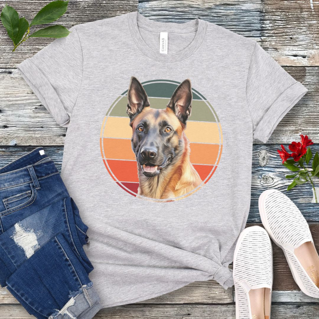 Grey t-shirt for Belgian Malinois lovers with a vintage sunset graphic and Malinois face, shown on a wooden surface with jeans and shoes.