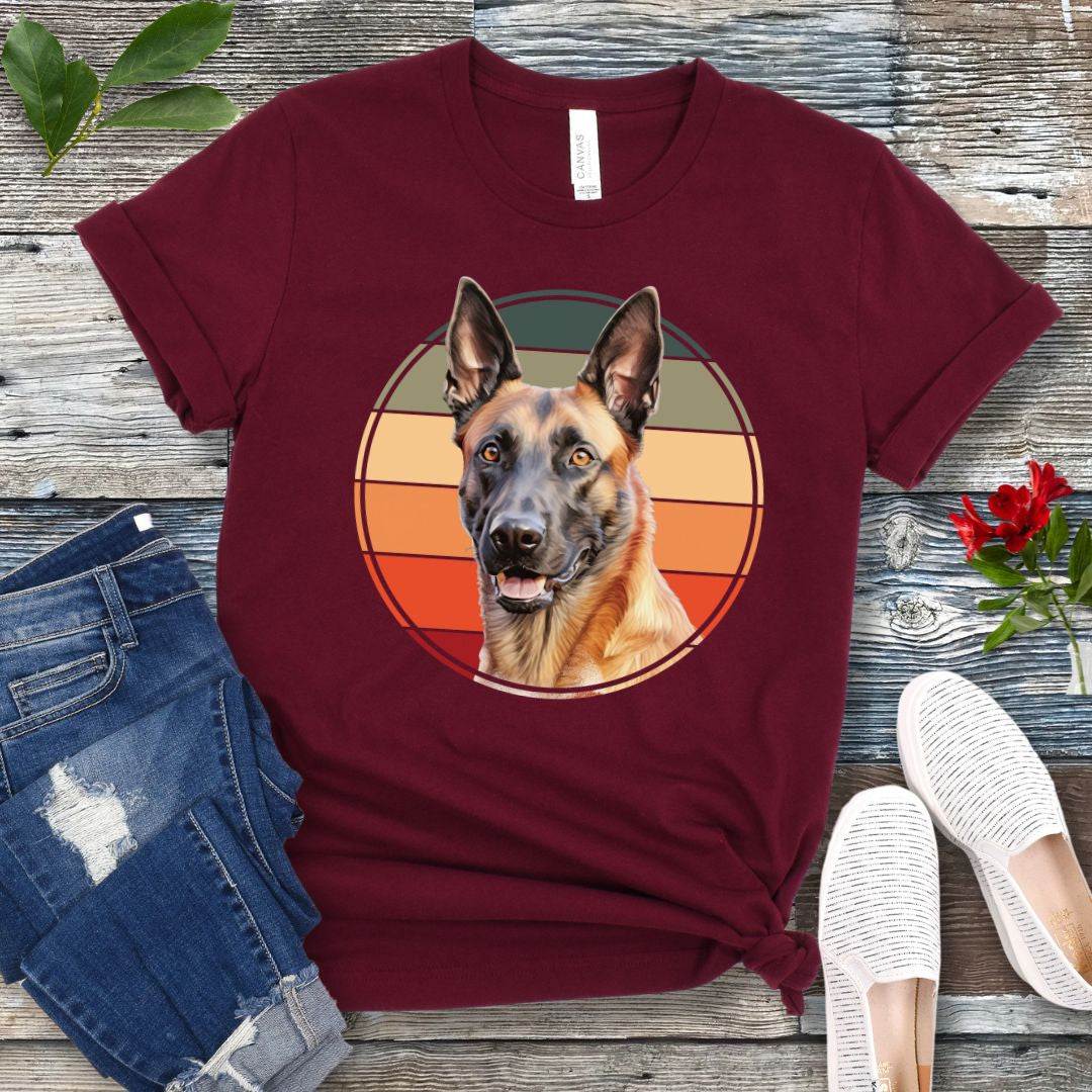 Maroon t-shirt for Belgian Malinois lovers with a vintage sunset graphic and Malinois face, shown on a wooden surface with jeans and shoes.